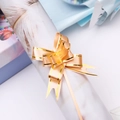 Close-up of champagne gold gift ribbon bow with gold trim on festive packaging paper - Orange Gold Edge