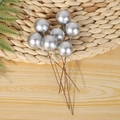 Detailed close-up of silver artificial berries on wire stems over a rustic woven mat - 1cm Christmas Silver Berry 1Pc