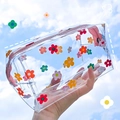 Borsa trasparente con fiori e zip rosa tenuta contro lo sfondo del cielo blu - Fiore Multicolore