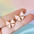 Pendientes de mariposa en acero inoxidable rosa y dorado mostrados sobre un dedo - Rosa