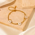 Close-up of golden double-layered bracelet with white shell flowers on a stone slab - Gold Daisy White Shell Double Layer Bracelet (A801)