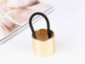 Barrette de queue de cheval en métal doré avec élastique noir sur un fond blanc minimaliste - Doré