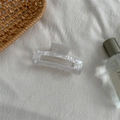 Primer plano de pinza de pelo de acetato mármol blanco sobre tela blanca texturizada - Blanco Mármol
