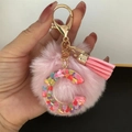 Detail of pink faux fur pom pom and resin letter C keychain with glitter heart sequins - Letter C