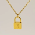Collier avec pendentif cadenas doré orné de la lettre gothique N sur fond beige épuré - Style Lettre N