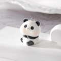 Macro shot of cute flocked panda pendant with soft texture and metal ring for DIY jewelry - Panda