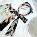 Elegant black fabric headband with colorful abstract print and long flowing ribbons - Black