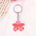 Détail du porte-clés chapeau rose pailleté et lunettes cœur sur fausse fourrure blanche - Chapeau de Lunettes de Soleil Coeur