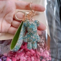 Sparkly blue-green rhinestone bear keychain with gold metal clip and green hand strap - Mixed Green