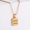 Macro view of gold-plated Aquarius zodiac pendant on a white geometric stand - Aquarius