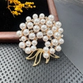 Close-up of elegant gold wreath brooch with white pearls and sparkling crystal bow details - BZ004 Bowknot Wreath