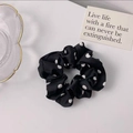 Polka dot silk scrunchie with white dots on black fabric displayed on a white surface - Black Polka Dot