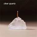 Gros plan d'un bâton d'encens brûlant sur un socle en cristal de quartz naturel - Cristal de roche