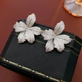 Makroaufnahme von silbernen Blumenohrringen mit weißen Zirkonia auf Lederetui - Fünfblättrige Blume / Silber Blumenstil