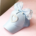 Detail of light blue mesh cap with large lace bow, pearls, and rhinestone heart accent - Trucker Hat / Blue