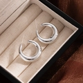 Polished silver chunky C-shaped hoop earrings displayed on elegant beige jewelry box - Silver Small C-Shape