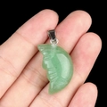 Handcrafted light green stone moon face pendant with silver clasp shown in hand - Green Aventurine