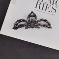 Detailed top view of a large black metal spider hair claw clip on a white decorative card - Exquisite Spider Hair Claw / Black