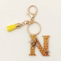 Detail of Letter N honeycomb acrylic keychain with bee charms and a yellow tassel - Letter N