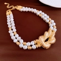 Macro detail of luxury double-strand baroque pearl necklace with gold knotted pendant - Necklace - Gold