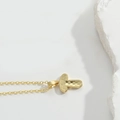 Minimalist gold mushroom pendant necklace with a textured hammered finish on white stone - Letter T