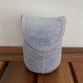 Vista detallada de bolsa de tela gris con ribete morado sobre textura de madera - Tarro Pequeño / Funda para Taza Gris 150ml