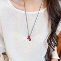 Close-up of red horse pendant necklace with black cord on a model neck - 19# Necklace Red Pony Pendant