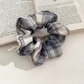 Blue-grey and beige checkered faux fur scrunchie resting on an open book - 1075C Gray Blue Plaid Scrunchie