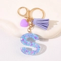 Close-up of letter S keychain with purple heart charm and gold-tone metal ring - Letter S