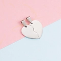 Close-up of polished stainless steel split heart pendants on pink and blue background - Steel Color (Left + Right Half Heart)