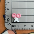 Vue macro détaillée du mini peigne canard en résine de 1 cm sur une grille graduée - 12*Ciseaux Mini