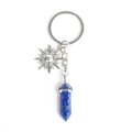 Blue hexagonal crystal column and silver sun pendant keychain on white background - Lapis Lazuli