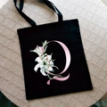 Black canvas tote bag with pink letter Q and white lily flower floral print - Letter Q / Black