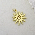 Dettaglio di un ciondolo a sole placcato oro con design a spirale e intarsio in zirconi - Sole a Spirale Oro