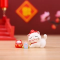 Cute white lucky cat ornament with red daruma doll and festive gold accessories - Daruma Blessing Cat (1081-18)