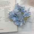 Blue fabric flower hair clip with realistic gradient petals on vintage book background - Light Blue Flower Banana Clip
