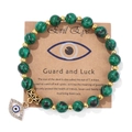 Bracelet en perles de turquoise verte avec pendentif œil maléfique doré sur carte - 19cm / Pierre Paon Verte