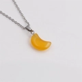 Gros plan détaillé du collier croissant de lune jaune avec chaîne en O argentée sur blanc - Jaune d'Or
