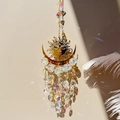 Detail of crystal suncatcher with gold moon patterns casting rainbow light on wall - AB Color Sun
