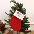 Red knitted Christmas stocking with embroidered letter X hanging on a pine tree branch - Letter X