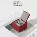 Écrin à bagues en velours rouge bordure dorée 6x6x4cm exposé sur un magazine - Boîte à bague / Rouge