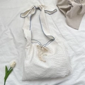Dettaglio della borsa in tela a pois testurizzata con tracolla regolabile a fiocco - Bianco Latte a Pois Con Bordo Blu Stile Fiocco