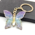 Detailed close-up of a gradient butterfly keychain with shimmering gold metal accents - Blue