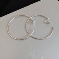 Close-up of minimalist silver hoop ear clips with clear silicone pads for non-pierced ears - 6cm / Silver / Clip-On Earrings