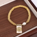 Pulsera dorada con perlas y medalla religiosa en una elegante caja de madera - Estilo 2