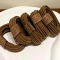 Detailed close-up of brown elastic hair ties with embossed bear leather fastener - Bear Patch Style / Medium Coffee