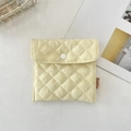 Détail d'une pochette matelassée cœur en jacquard jaune clair avec bouton pression et logo - Jaune