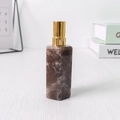 Seifenspender mit braunem Marmormuster und goldener Pumpe auf Holztisch - Rauchquarz