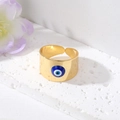 Vue détaillée d'une bague Evil Eye dorée avec émail bleu sur une surface en pierre - Mauvais Œil Bleu Royal