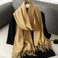 Detail shot of camel cashmere scarf texture and elegant fringe hanging on a rack - Light Camel